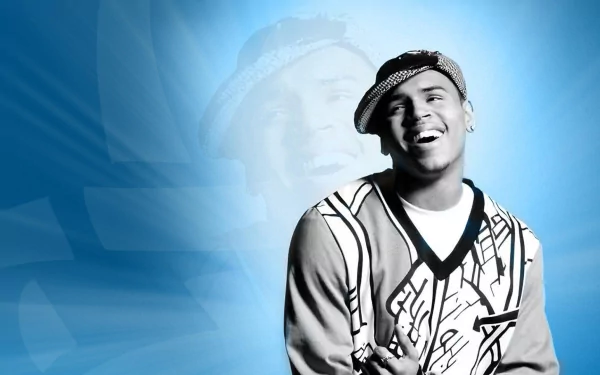 A vibrant HD desktop wallpaper featuring Chris Brown, smiling against a dynamic blue background, capturing the energy of music and performance.