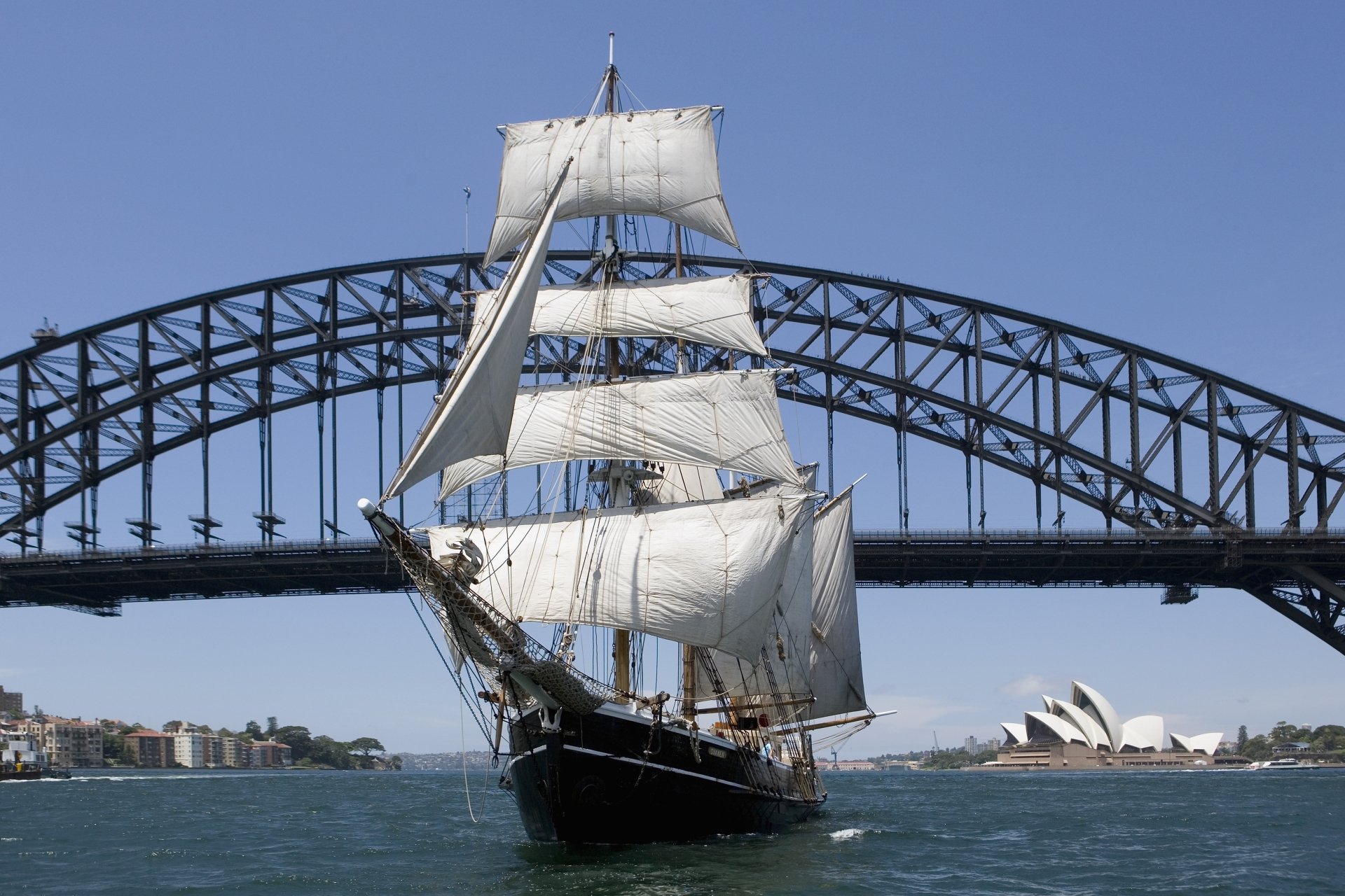 A schooner sailing in Sydney Harbour with the Sydney Opera House and Sydney Harbour Bridge in the background, captured in 4K Ultra HD.