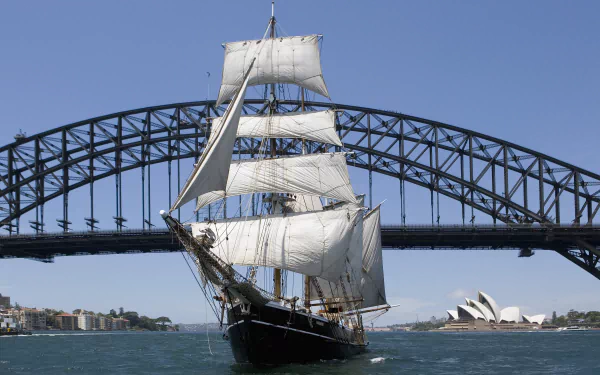 A schooner sailing in Sydney Harbour with the Sydney Opera House and Sydney Harbour Bridge in the background, captured in 4K Ultra HD.