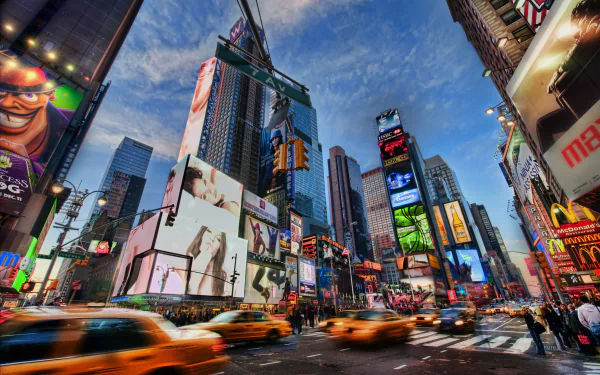 Vibrant 4K Ultra HD image of Times Square at dusk, showcasing bright digital billboards, bustling traffic, and towering skyscrapers in this iconic man-made urban scene.