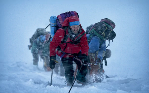 Climbers ascending Everest in a snowstorm, captured in a high-definition wallpaper.