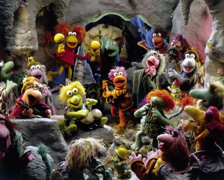 HD PC desktop wallpaper of Fraggle Rock from The Muppets TV show, featuring colorful Fraggles and puppet characters gathered in a lively cave scene.