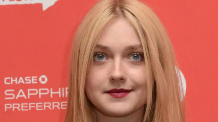 Close-up HD desktop wallpaper of celebrity Dakota Fanning with long blonde hair and red lipstick against a red background.