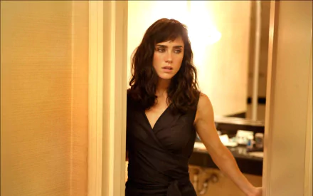 Dark-haired woman in a sleeveless black dress steps through a doorway, warm bathroom light behind her — 2K Quad HD PC desktop wallpaper from the movie Little Children.