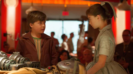 Warm-lit 4K Ultra HD desktop wallpaper: two children in a retro-futuristic diner surrounded by machinery, sharing a tense moment — a still evoking the movie Tomorrowland.