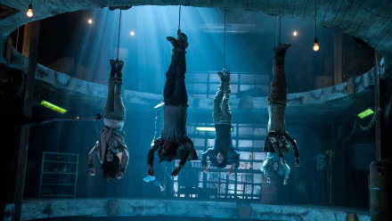 Image of characters from Maze Runner: The Scorch Trials, featuring Ki Hong Lee, Dylan O'Brien, Kaya Scodelario, and Thomas Brodie-Sangster, suspended in a dramatic, dimly lit setting.