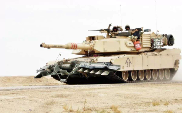 HD desktop wallpaper featuring a desert-colored M1A1 Abrams military tank positioned on sandy terrain, showcasing its powerful design and armored details.