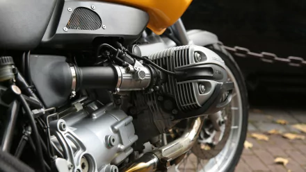 Close-up 4K Ultra HD wallpaper of a motorcycle engine, showcasing detailed mechanical components on a bike with a yellow body, against a dark, blurred background.