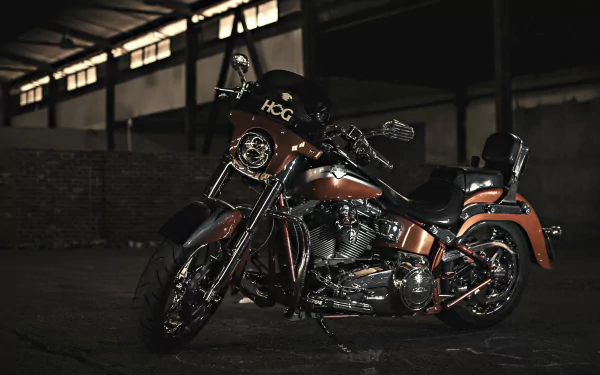 A dark and striking HD wallpaper featuring a Harley-Davidson motorcycle, showcasing its detailed design and powerful stance in an industrial setting.