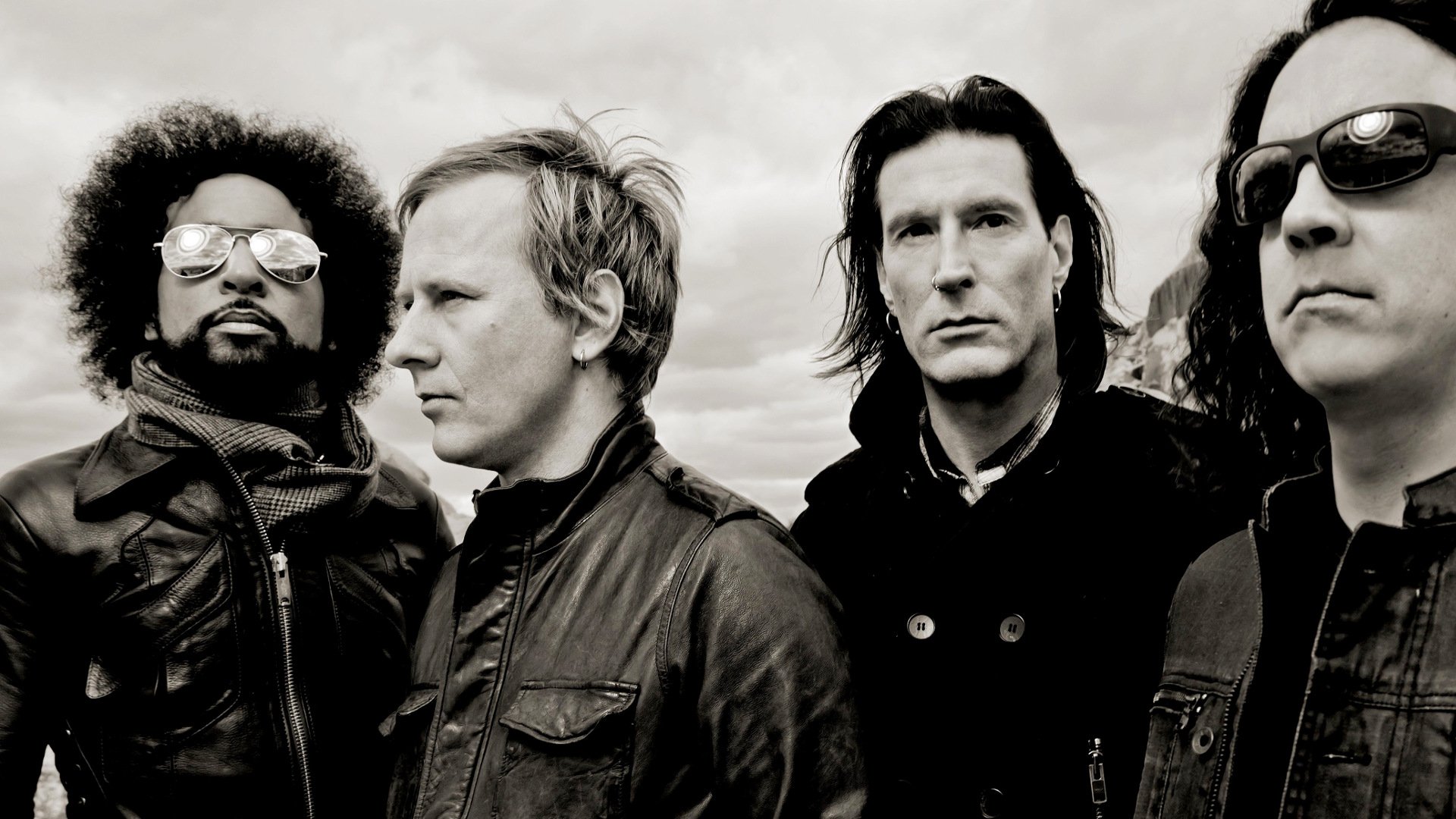 HD PC desktop wallpaper featuring the rock band Alice In Chains in a moody outdoor setting, emphasizing their distinctive music style and presence.