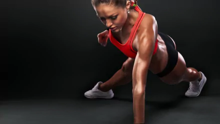 A fit athlete performs a dynamic move, showcasing strength and determination against a dark background. This HD wallpaper captures the essence of fitness and sports.