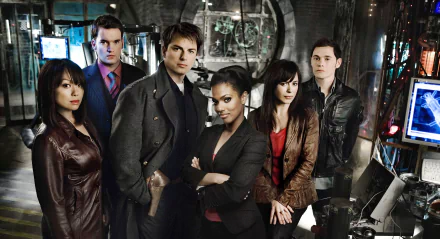 Cast of the TV show Torchwood posed in a dimly lit, high-tech setting, featured in a 4K Ultra HD PC desktop wallpaper and background.