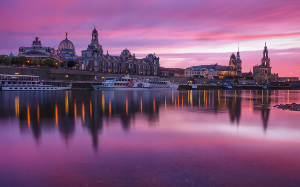 A stunning 4K Ultra HD image of Dresden’s man-made skyline at sunset, with historic buildings reflected in calm waters under a vibrant purple and pink sky.