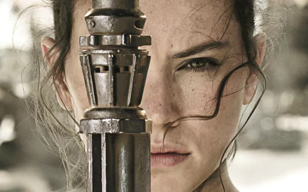 Daisy Ridley portrays Rey in this striking HD wallpaper from Star Wars Episode VII: The Force Awakens, featuring her intense gaze and iconic weapon.