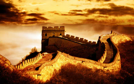 HD desktop wallpaper showing the man-made Great Wall of China winding through a mountainous landscape under a dramatic golden sky.