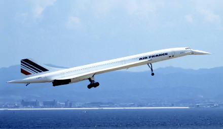4K Ultra HD desktop wallpaper featuring an Air France Concorde aircraft taking off over the ocean with mountains in the background.