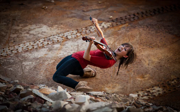 A dynamic 4K Ultra HD PC wallpaper featuring Lindsey Stirling playing the violin energetically against a textured, earthy background.