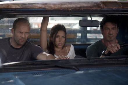 A tense moment in The Expendables featuring Jason Statham as Lee Christmas, Giselle Itié as Sandra, and Sylvester Stallone as Barney Ross in a gritty car interior.