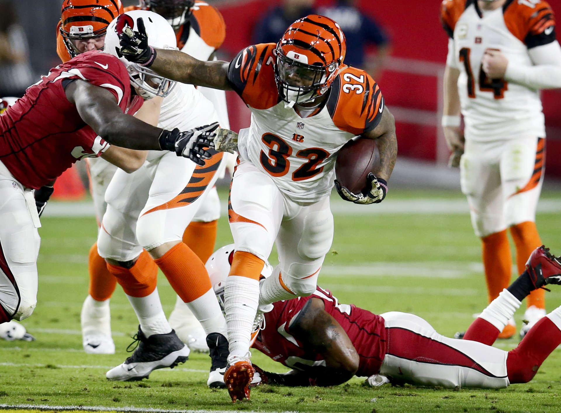 2K Quad HD PC desktop wallpaper showing a Cincinnati Bengals ball carrier powering through tacklers on the field in intense, high-energy NFL game action.