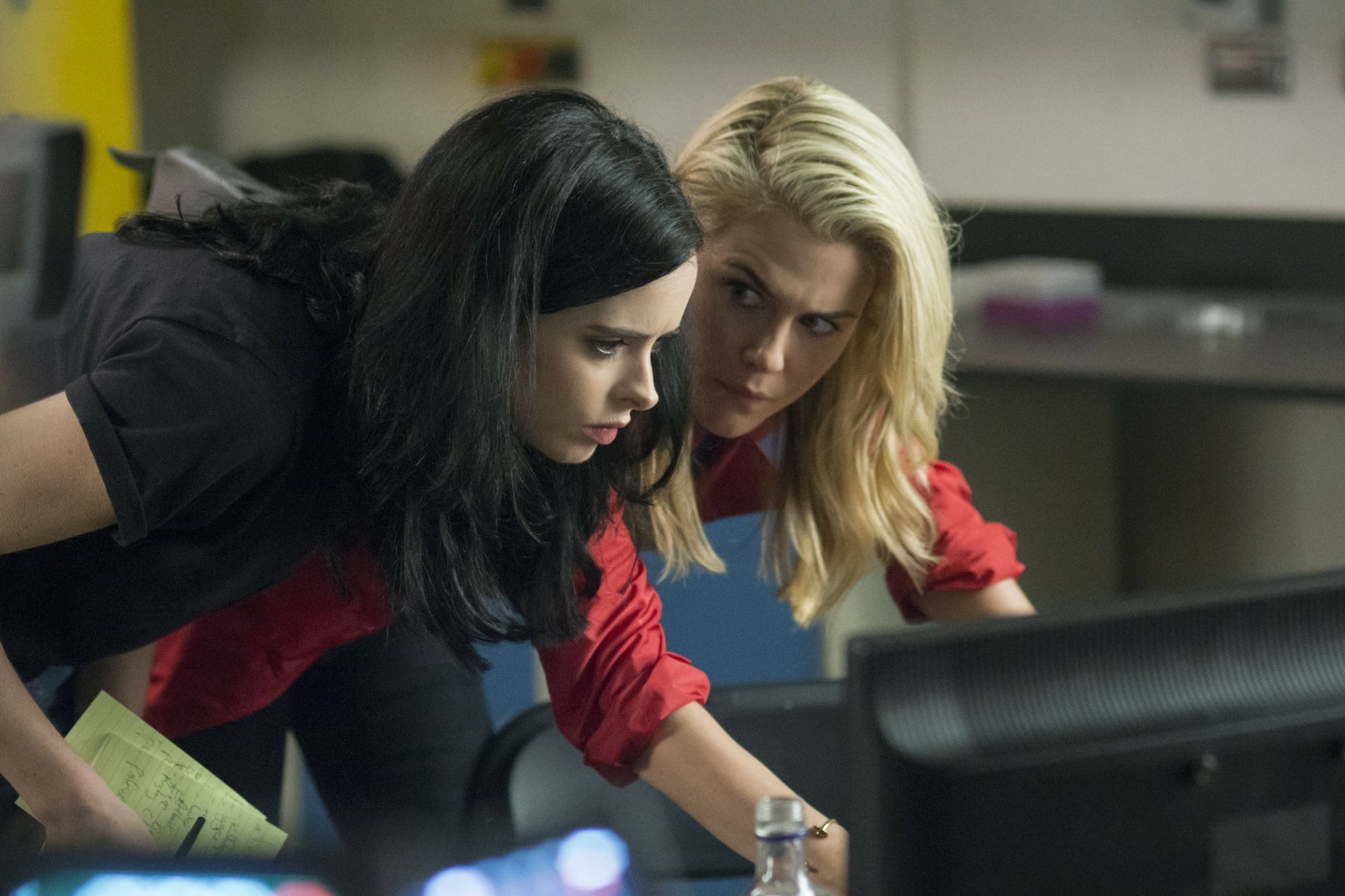Jessica Jones and Hellcat, portrayed by Krysten Ritter and Rachael Taylor, intensely examine a computer screen in this 4K Ultra HD desktop wallpaper from the Marvel TV show.