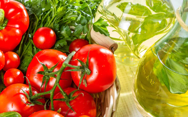 Vibrant red tomatoes and fresh greens next to a glass bottle of oil, captured in a detailed 4K Ultra HD desktop wallpaper showcasing fresh fruit and food elements.