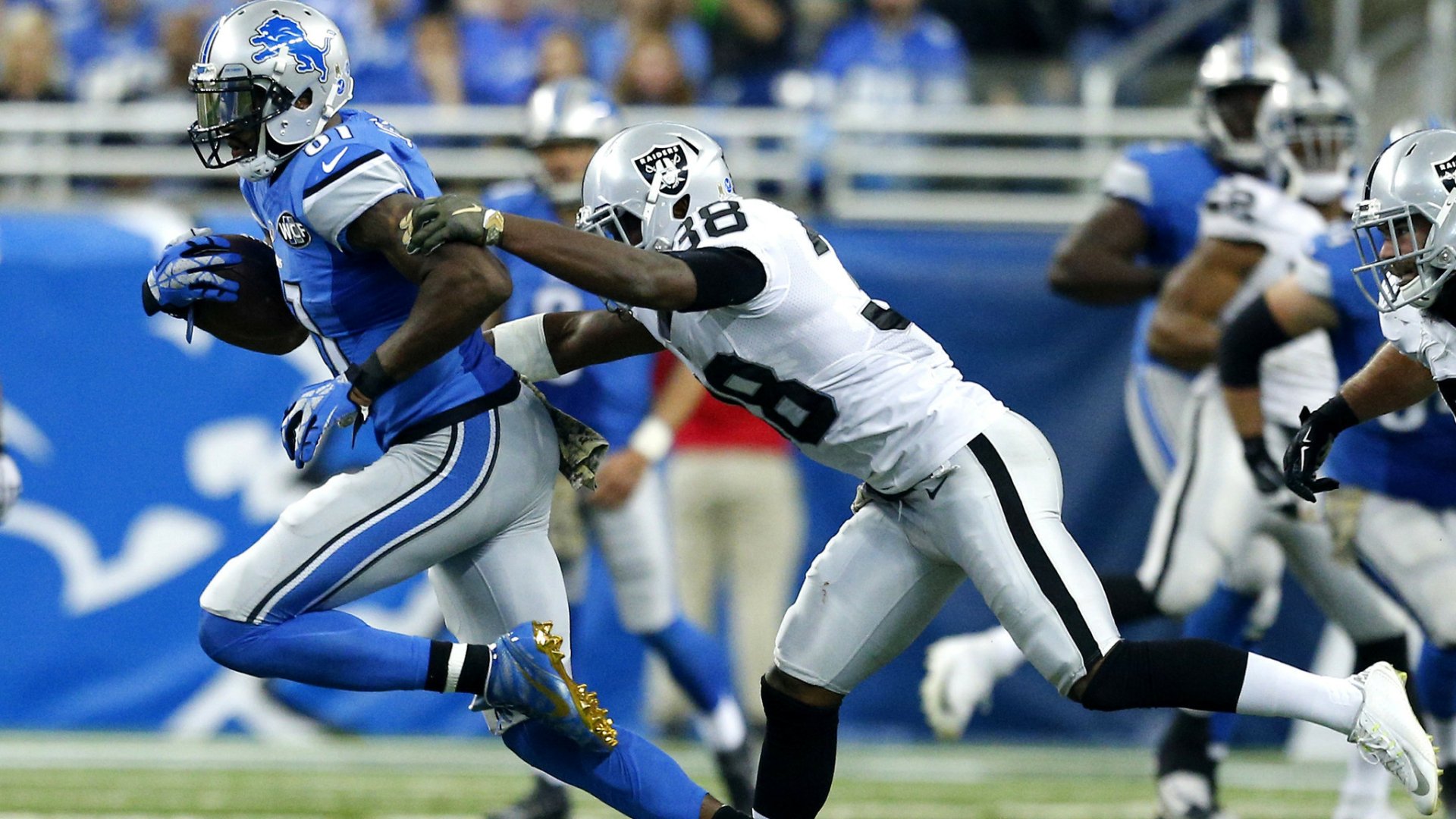 HD PC desktop wallpaper background showing Las Vegas Raiders defender pursuing a Detroit Lions ballcarrier in high-speed NFL game action.