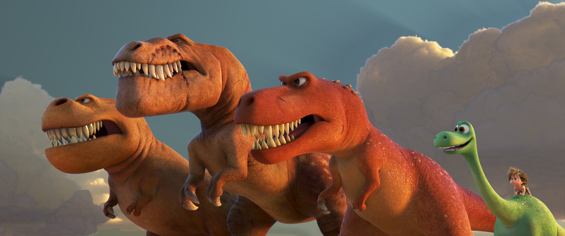 A high-definition desktop wallpaper featuring Spot and Arlo from Disney Pixar's movie The Good Dinosaur, alongside two menacing T-Rex dinosaurs against a cloudy sky.