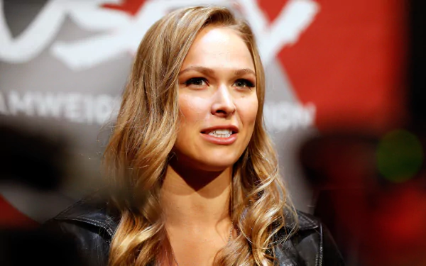 A vibrant 4K Ultra HD desktop wallpaper featuring Ronda Rousey, showcasing her dynamic presence in the sports world against a striking backdrop.