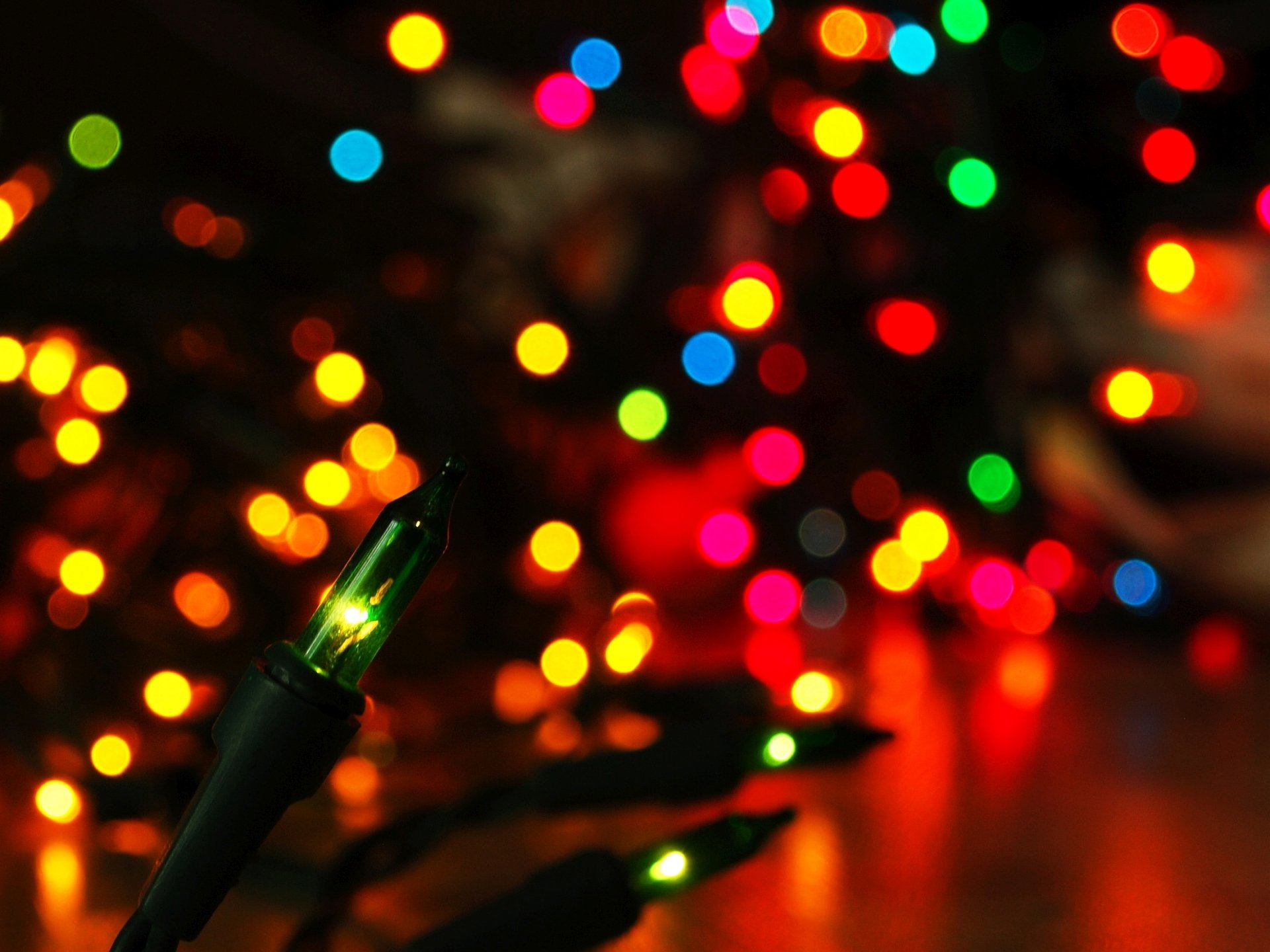 HD PC desktop wallpaper featuring vibrant, colorful Christmas lights creating a festive holiday atmosphere with glowing red, green, yellow, and blue bokeh effects.