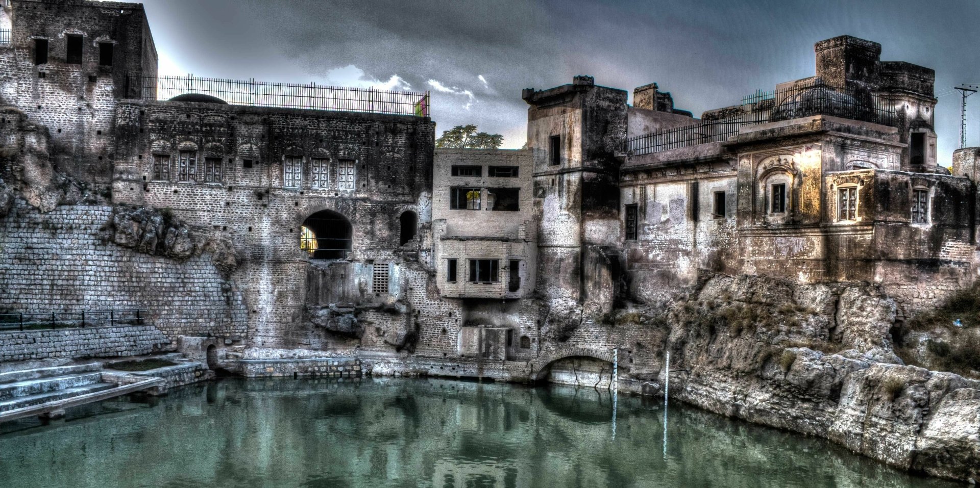 HDR image of Katasraj Temple in Pakistan with calm water reflecting the ancient religious site, captured as a high-definition desktop wallpaper background.