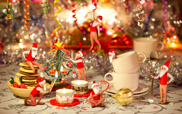 A festive 4K Ultra HD PC desktop wallpaper featuring playful elves with Christmas decorations, cookies, candles, and holiday cups amid sparkling background lights.