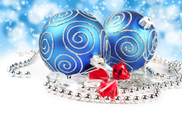 A vibrant 8K Ultra HD Christmas desktop wallpaper featuring blue holiday ornaments with silver swirls, red gems, and silver bead garlands against a sparkling backdrop.