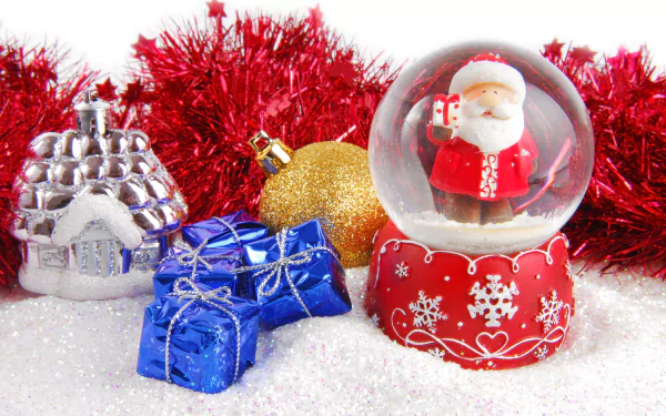 A 4K Ultra HD desktop wallpaper featuring a festive Christmas snow globe with Santa, surrounded by holiday ornaments and red tinsel on a snowy surface.