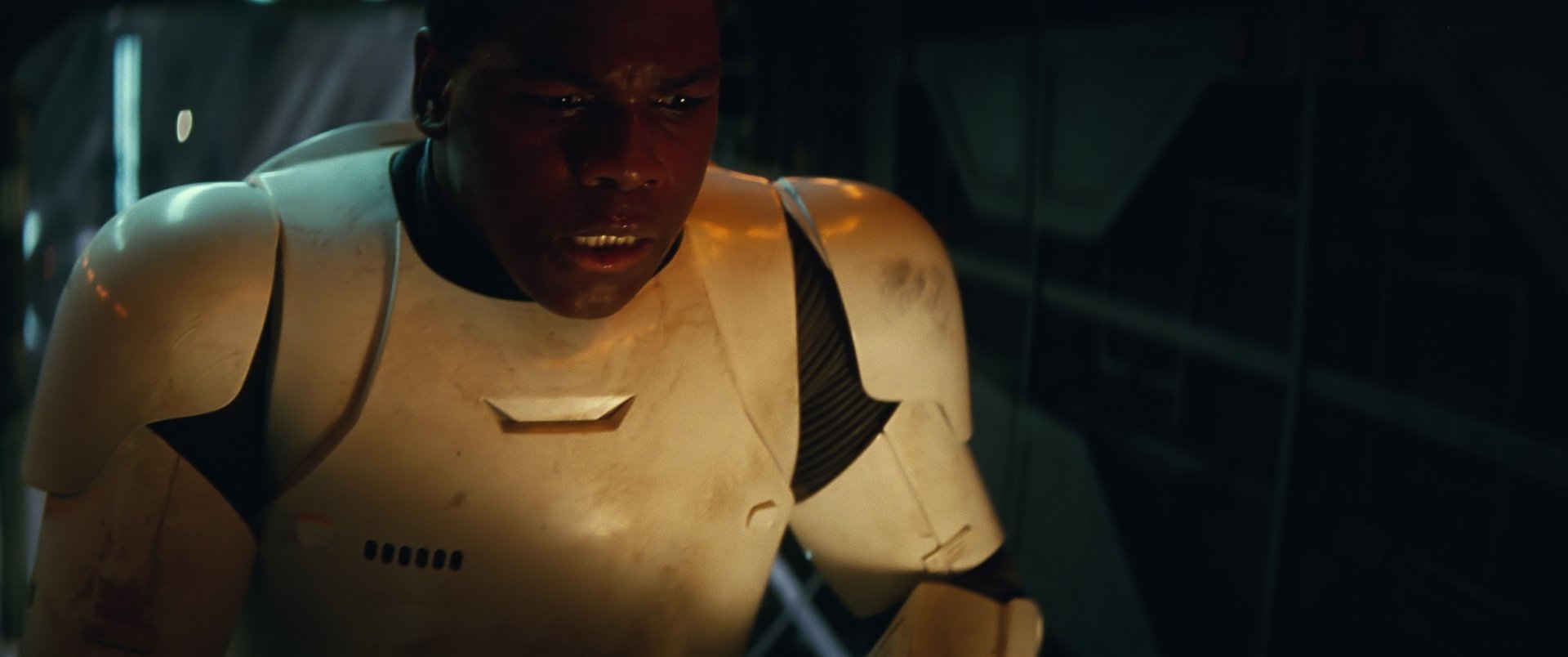 HD desktop wallpaper of Finn, portrayed by John Boyega, from Star Wars Episode VII: The Force Awakens wearing stormtrooper armor in a dimly lit scene.