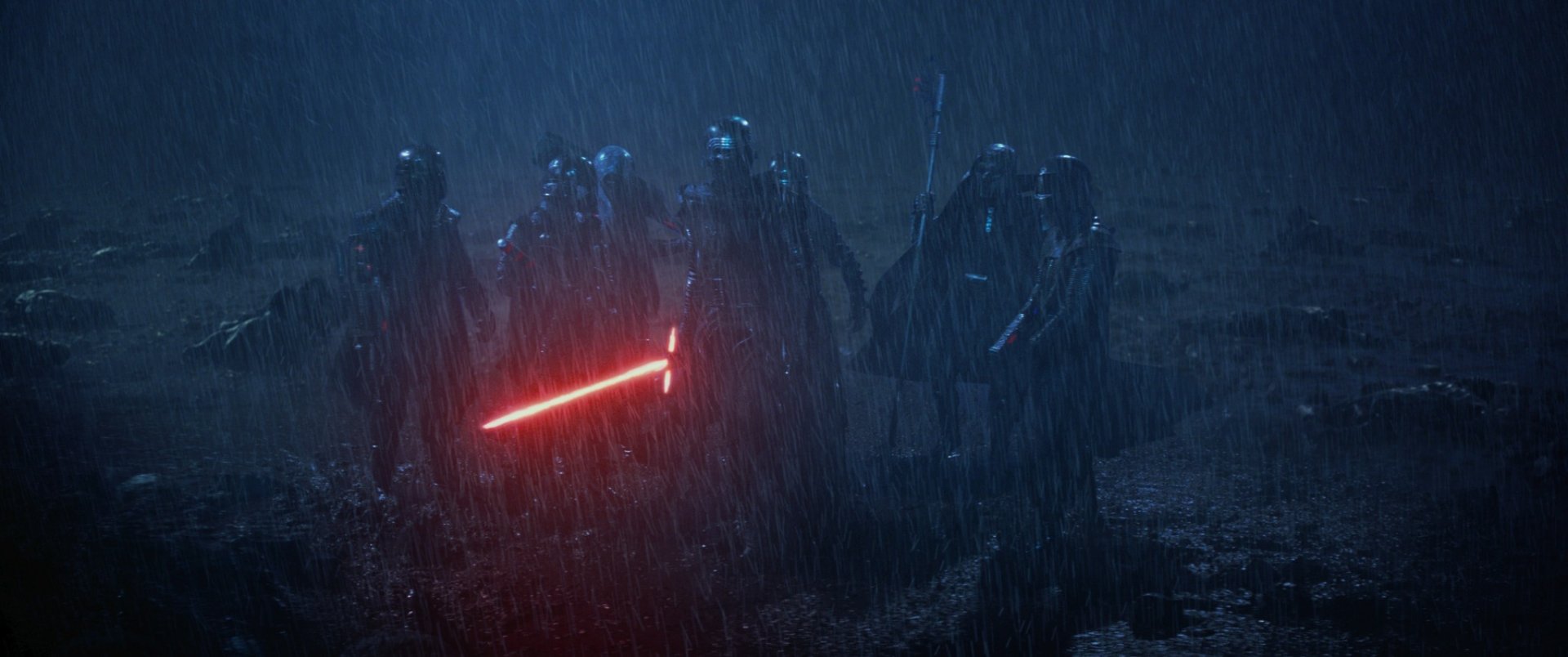 A dramatic HD wallpaper from Star Wars Episode VII: The Force Awakens, featuring Kylo Ren wielding a glowing red lightsaber amidst a rainy, tense scene with dark figures.