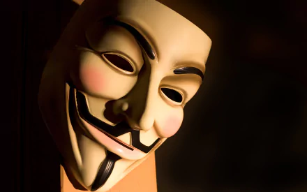 HD desktop wallpaper featuring a close-up of an iconic anonymous mask in dim lighting, representing technology and anonymity.