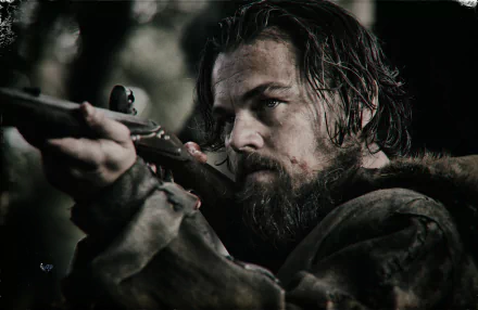 HD wallpaper of Leonardo DiCaprio in The Revenant, focused and aiming a rifle, with a rugged, survivalist backdrop.