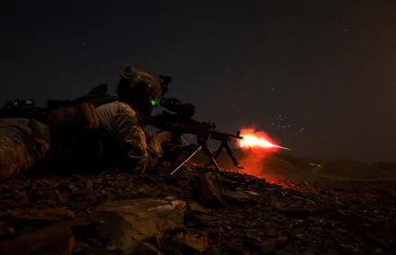 Military soldier firing a weapon at night, captured in an intense moment with muzzle flash, designed as an HD PC desktop wallpaper and background.