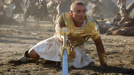 HD PC desktop wallpaper from the movie Exodus: Gods and Kings, featuring a warrior in ancient Egyptian armor holding a sword in a battle scene.