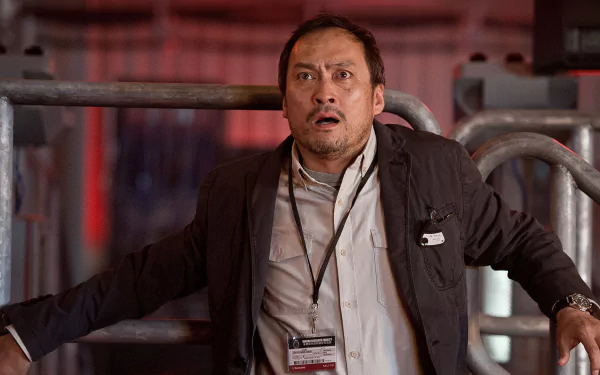 HD PC desktop wallpaper/background: tense scene from the movie Godzilla (2014) showing a shocked man gripping metal railings as red emergency lights flare in an industrial setting.