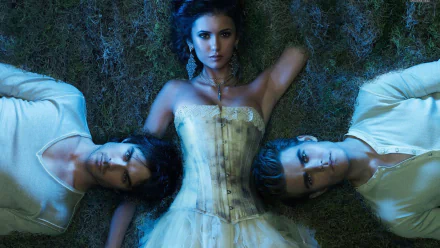 HD wallpaper from the TV show The Vampire Diaries features a striking scene with the main characters lying on the ground, surrounded by an atmospheric blue light.