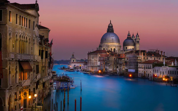 Evening view of Venice's Grand Canal at night, showcasing historic buildings and a serene waterway under a colorful sky, captured in HD for a PC desktop background.