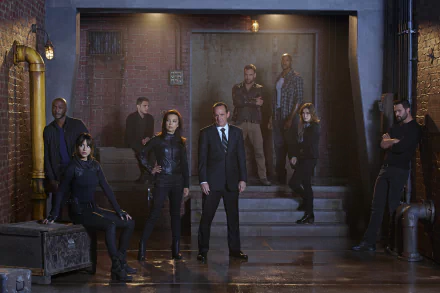 A dramatic scene from Marvel's Agents of S.H.I.E.L.D., featuring a group of characters posing confidently in a dimly lit urban setting with industrial elements.