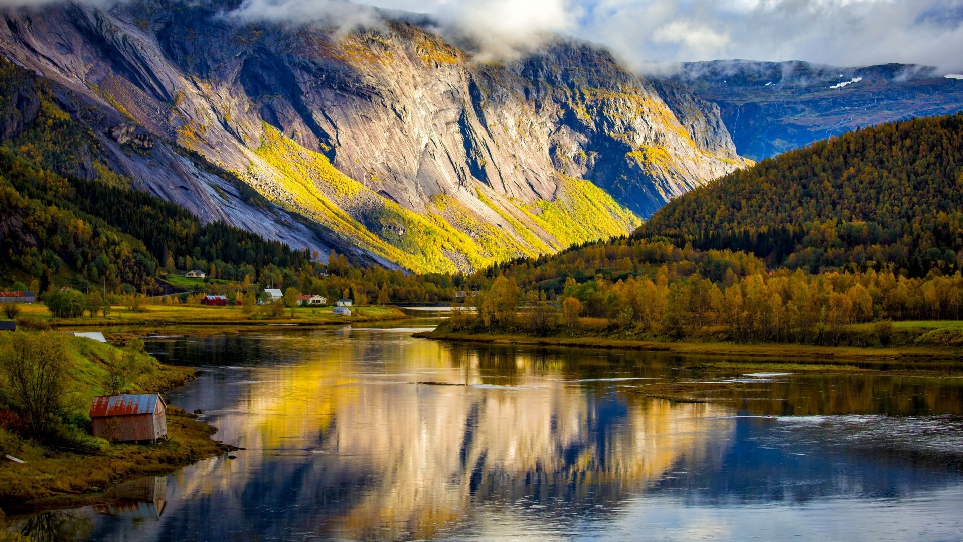 HD photography of a serene mountain landscape with autumn trees and a calm river reflecting the sky, used as a PC desktop wallpaper and background.