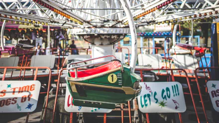 A vibrant amusement park scene featuring colorful seats and enticing signage, captured in high-definition for a captivating desktop wallpaper or background.