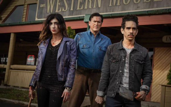 TV show Ash vs. Evil Dead 2K Quad HD PC desktop wallpaper: three blood-smeared protagonists stand grimly before a Western saloon, weapons at the ready.