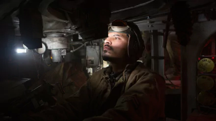Michael Peña in a gripping scene from the movie Fury, focused inside a tank. This HD wallpaper captures the intense atmosphere of wartime action.
