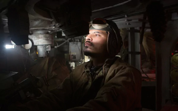 Michael Peña in a gripping scene from the movie Fury, focused inside a tank. This HD wallpaper captures the intense atmosphere of wartime action.