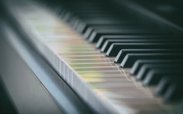 Close-up of piano keys with artistic bokeh lighting, captured in stunning 4K Ultra HD resolution for a vibrant music-themed desktop background.
