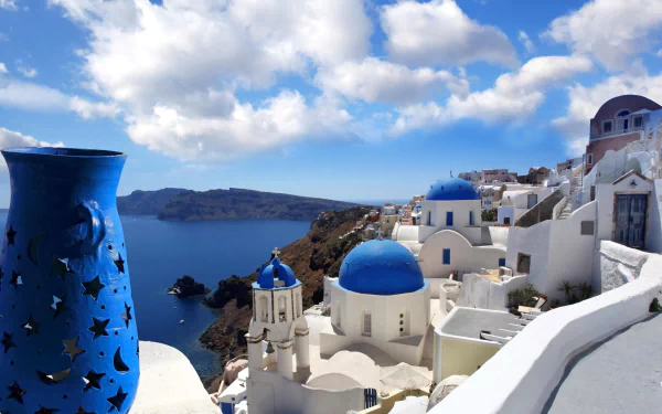 A stunning view of the ocean and traditional dome houses in Santorini, Greece, showcasing the vibrant blues and whites of this iconic man-made landscape.